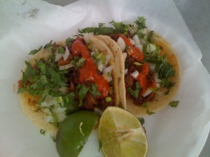 One lengua taco, one taco al pastor. Two crappy-looking limes.